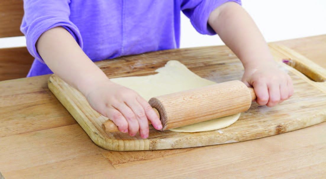 child rolling dough